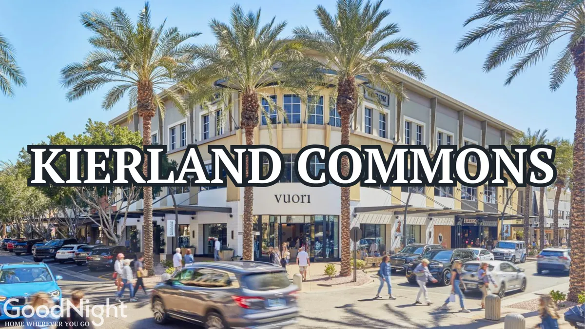 This lively exterior image captures the Kierland Commons building flanked by palm trees, with people walking and cars parked nearby. The scene is bustling, reflecting a popular shopping and dining destination for families.